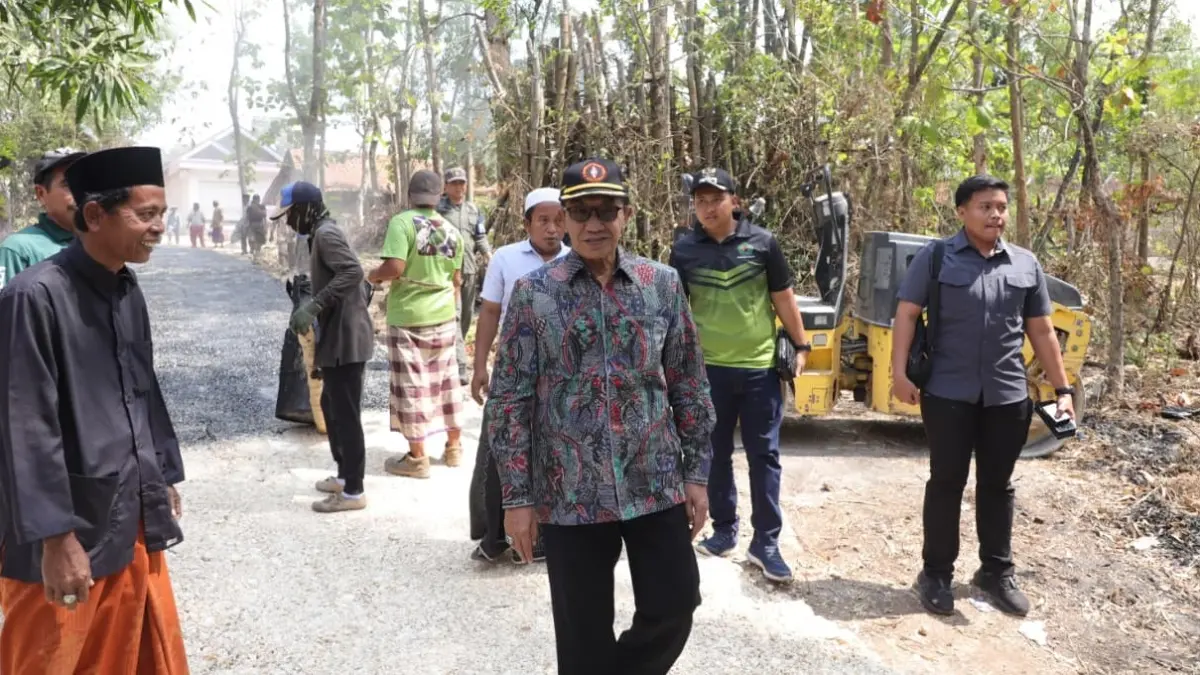 DISAMBUT BAIK: Bupati Pamekasan KH. Kholilurrahman meninjau perbaikan jalan swadaya di Desa Campor, Kecamatan Proppo, Sabtu (15/8). (PROKOPIM UNTUK JPRM)