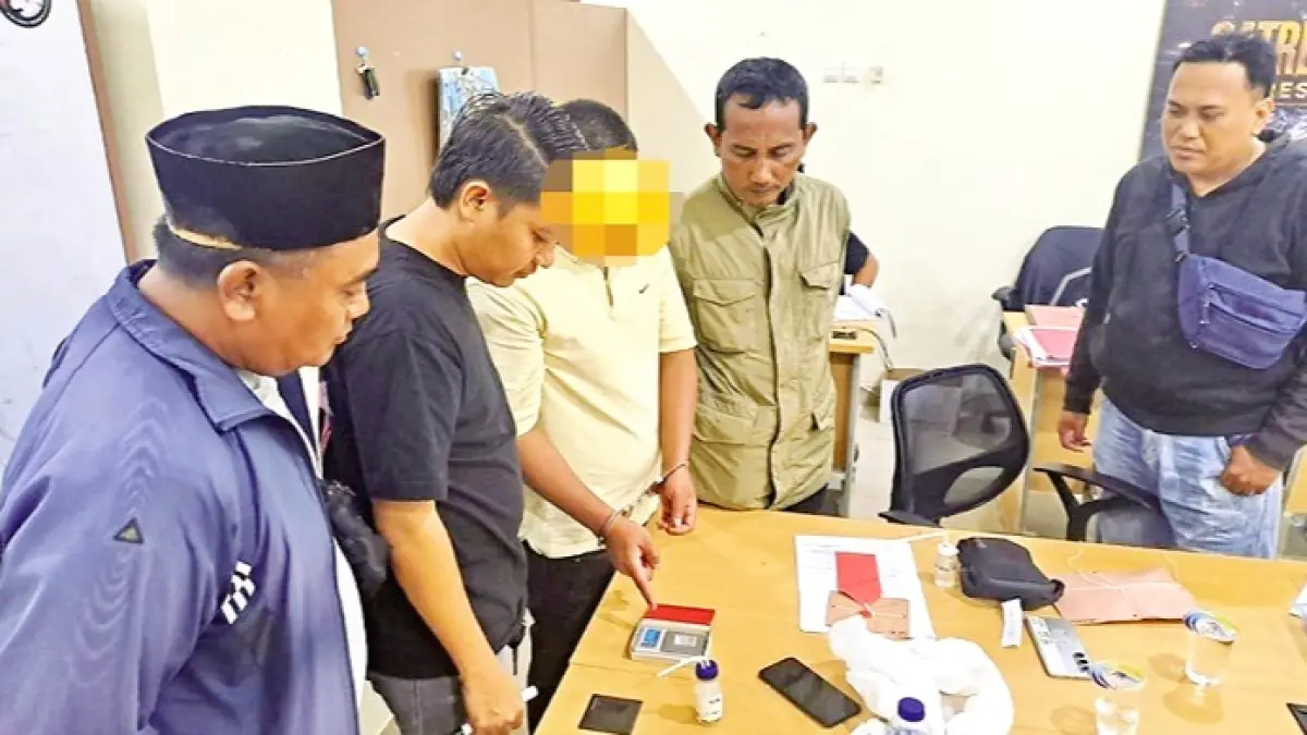 DIAMANKAN: AM, warga Kelurahan Lawangan Daya, Kecamatan Pademawu, menunjukkan barang bukti penyalahgunaan narkoba saat menjalani pemeriksaan di Polsek Palengaan, Pamekasan, Jumat (14/8). (POLRES PAMEKASAN UNTUK JPRM)