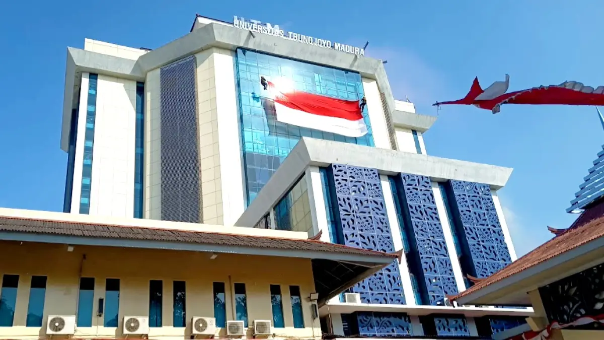 BERANI: Sekar Ayu Widyaratri (kiri) dan Indah Fitria membentangkan bendera Merah Putih di atas ketinggian 15 meter Gedung Rektorat UTM Senin (17/8). (ZEINAL ABIDIN/JPRM)