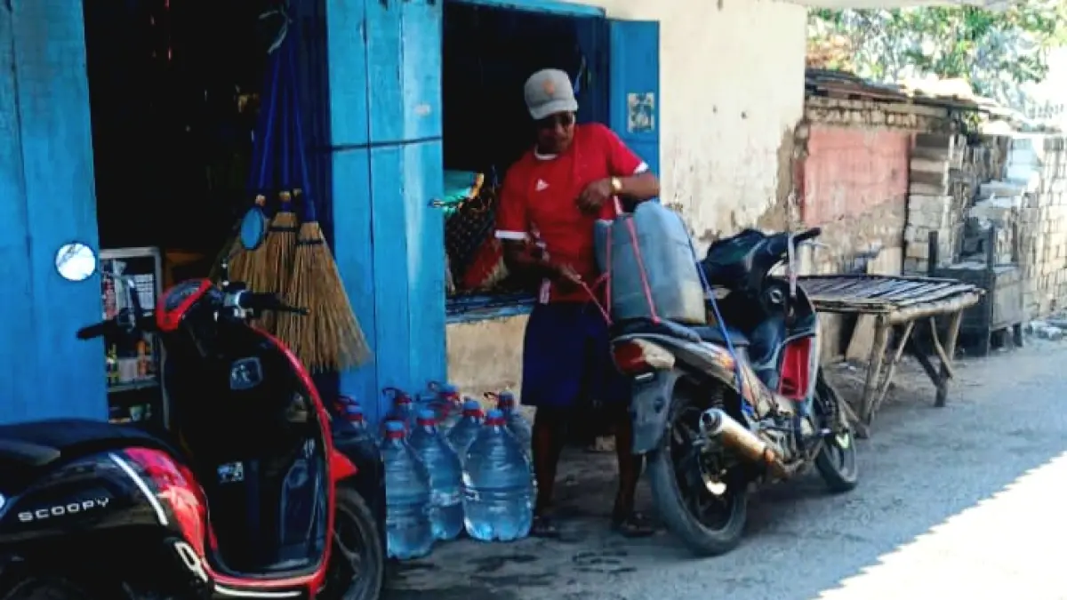 DIJUAL: Warga membeli air tandon hasil menadah air hujan di Desa Pulau Mandangin, Sampang, Minggu (16/8). (ADI UNTUK JPRM)