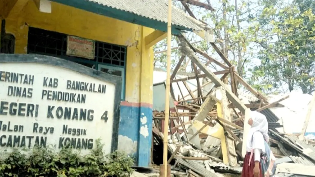 HORMAT GRAK!: Nuri Fauzia Ahadini, siswa kelas V SDN Konang 4, Kecamatan Konang, Bangkalan, memberi hormat pada Sang Saka Merah Putih di halaman sekolahnya yang ambruk, Minggu (16/8). (SDN KONANG 4 UNTUK JPRM)