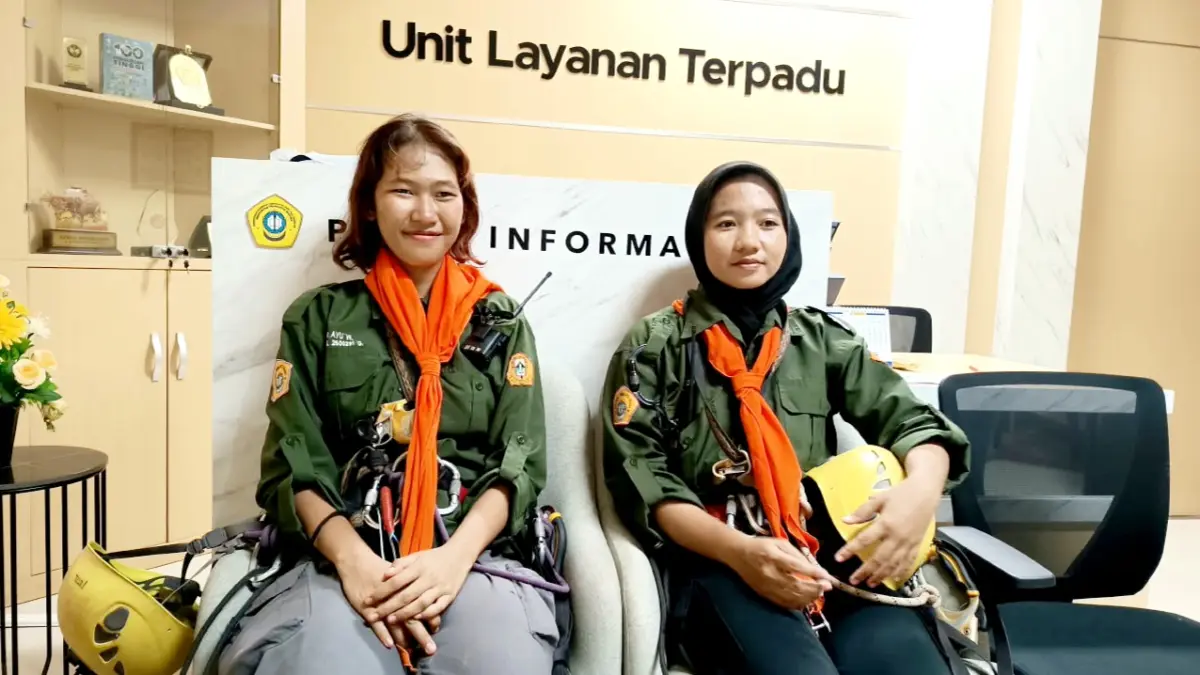 SEMANGAT MEMBARA: Sekar Widyaratri dan Indah Fitria seusai memanjat dinding Gedung Rektorat UTM untuk membentangkan bendera Merah Putih berukuran 10x7 meter. (ZEINAL ABIDIN/JPRM)