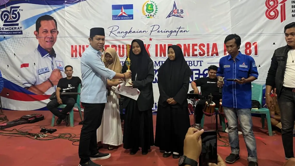 APRESIASI: Ketua Fraksi Demokrat sekaligus Ketua Komisi IV DPRD Sumenep Mulyadi menyerahkan piala kepada pemenang lomba Agustusan, Minggu (16/8) malam.