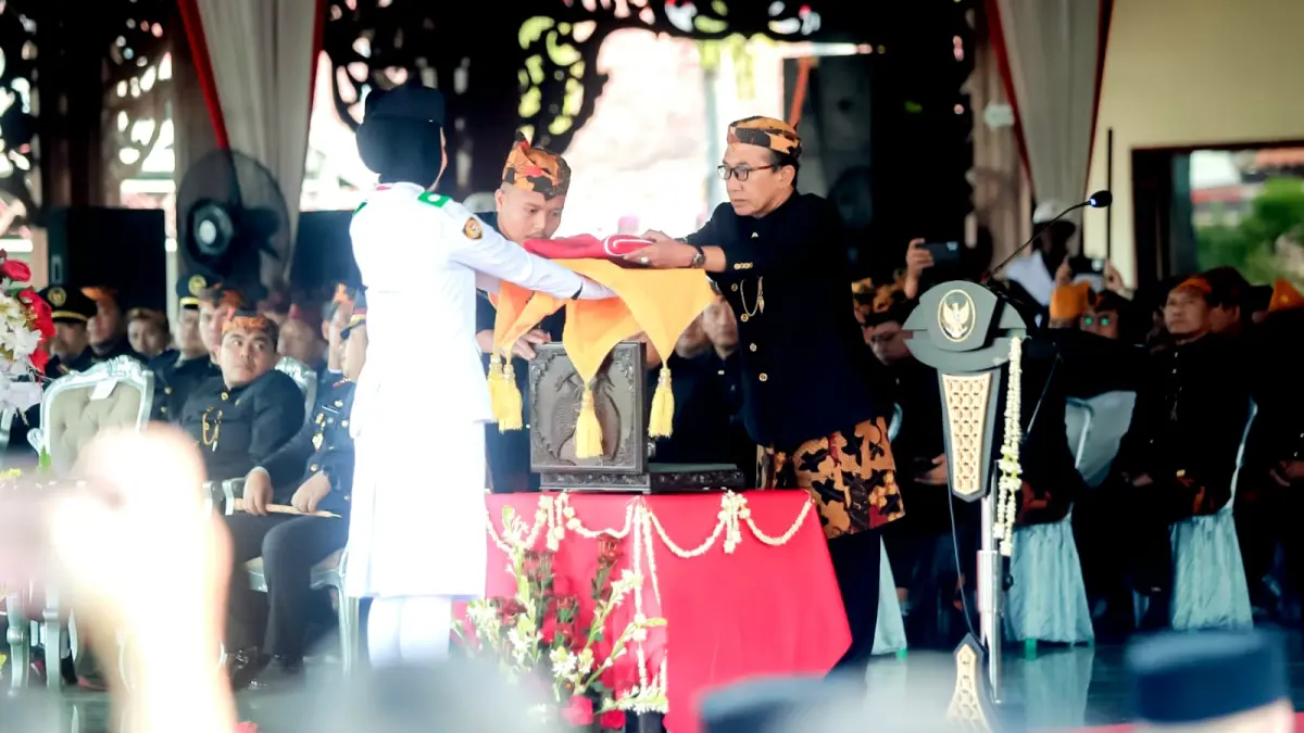 IDENTITAS BANGSA: Bupati Pamekasan KH. Kholilurrahman menyerahkan bendera Merah Putih kepada Paskibraka upacara peringatan HUT Ke-81 Kemerdekaan RI di Pendopo Ronggosukowati, Senin (17/8). (M. KHOLIL RAMLI/JPRM)