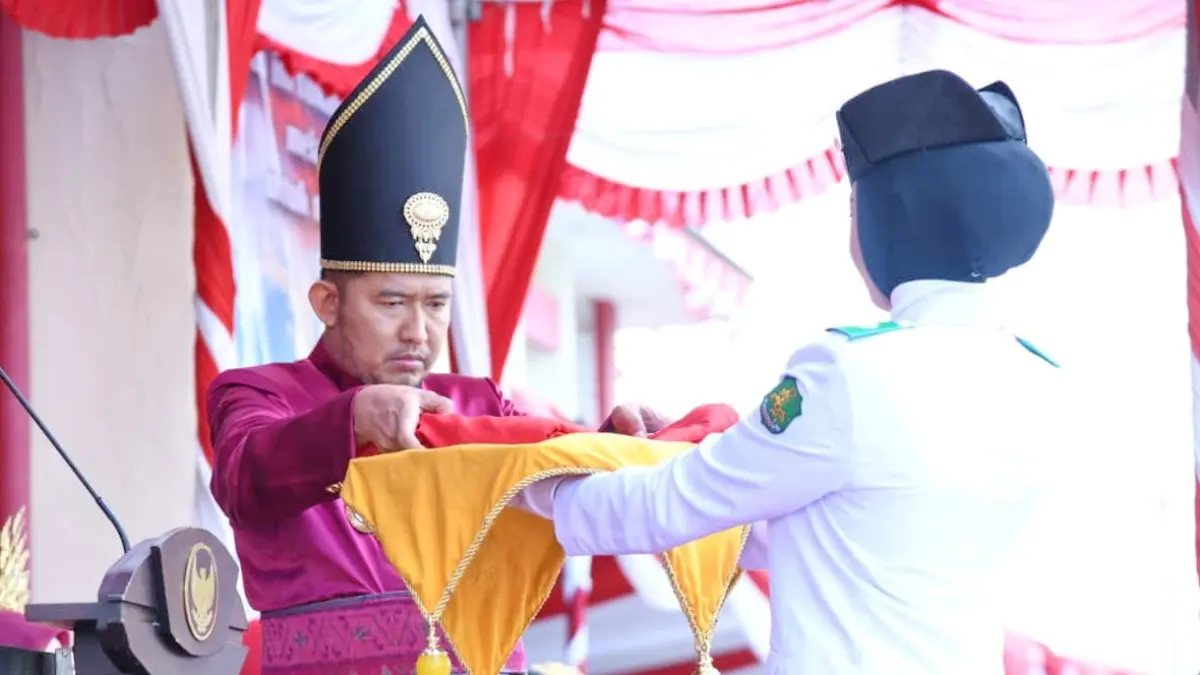 KHIDMAT: Penyerahan bendera merah putih oleh Bupati Sumenep kepada petugas pembawa baki saat Upacara Peringatan Hari Kemerdekaan Ke-81 RI, Senin (17/1)