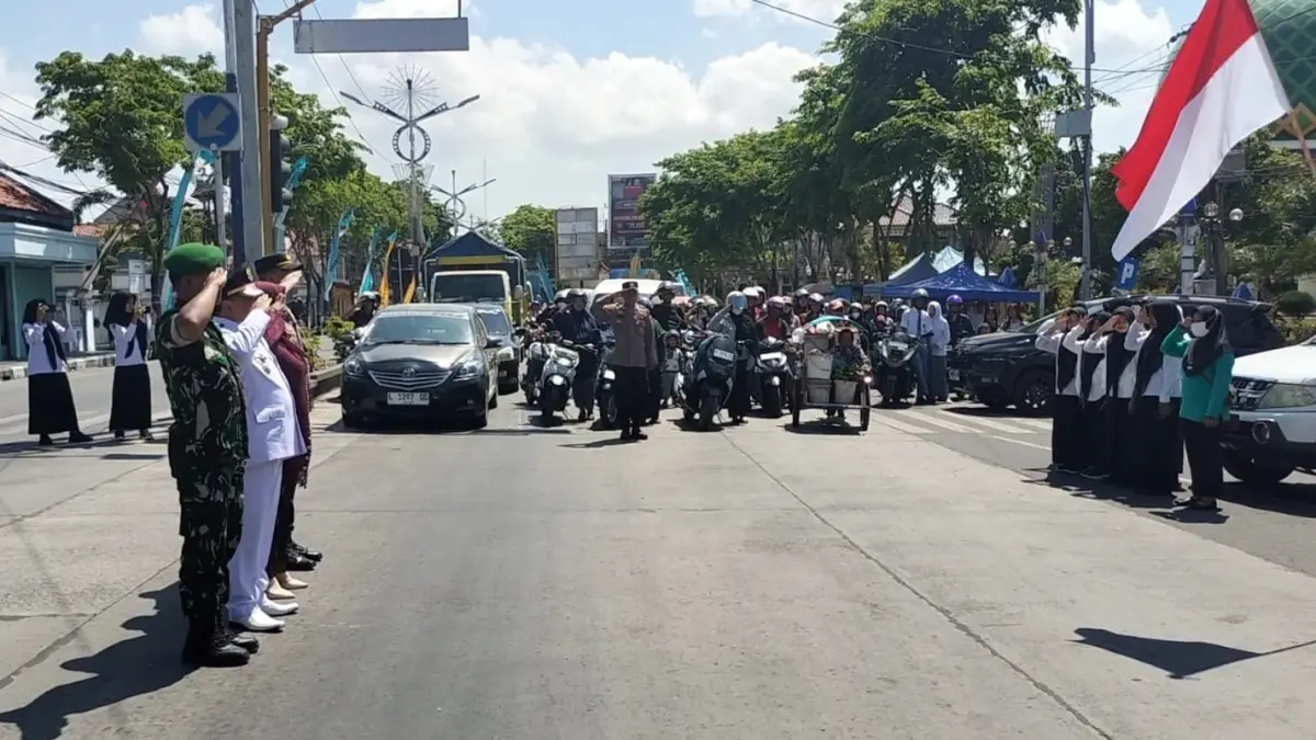 MERDEKA: Pengendara kendaraan bermotor dan forkopimka melakukan penghormatan kepada Sang Saka Merah Putih pada detik-detik Proklamasi Kemerdekaan RI di persimpangan Jalan Monumen Trunojoyo, Sampang, Senin (17/8).