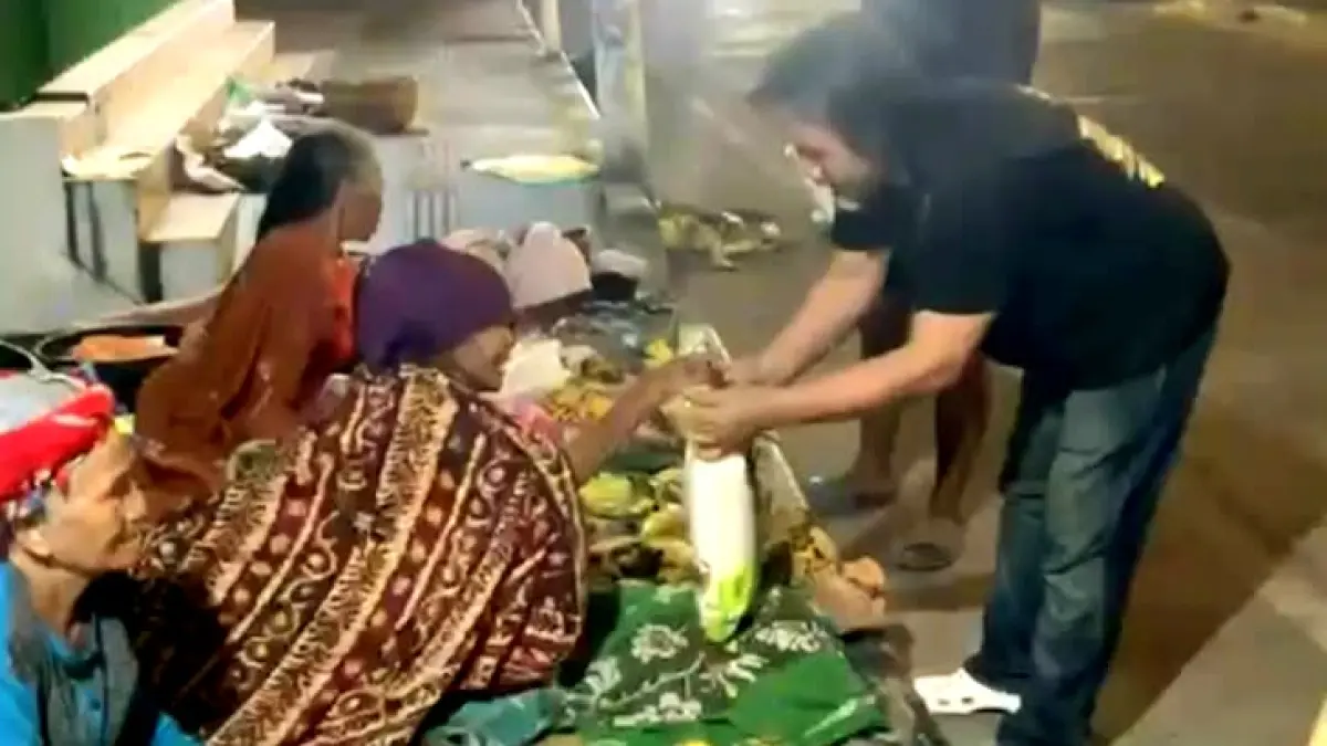 PEDULI: Katim URC Satreskrim Polres Sampang Aiptu Achson Yudianto memberikan beras kepada penjual buah di Jalan Imam Bonjol, Sampang, Senin (17/8). (POLRES SAMPANG UNTUK JPRM)
