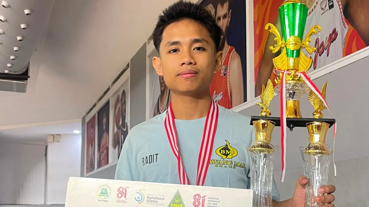 BANGGA: Atlet tenis meja Pamekasan Raditya Mario Ghandi memamerkan medali dan piala usai Kejurnas.