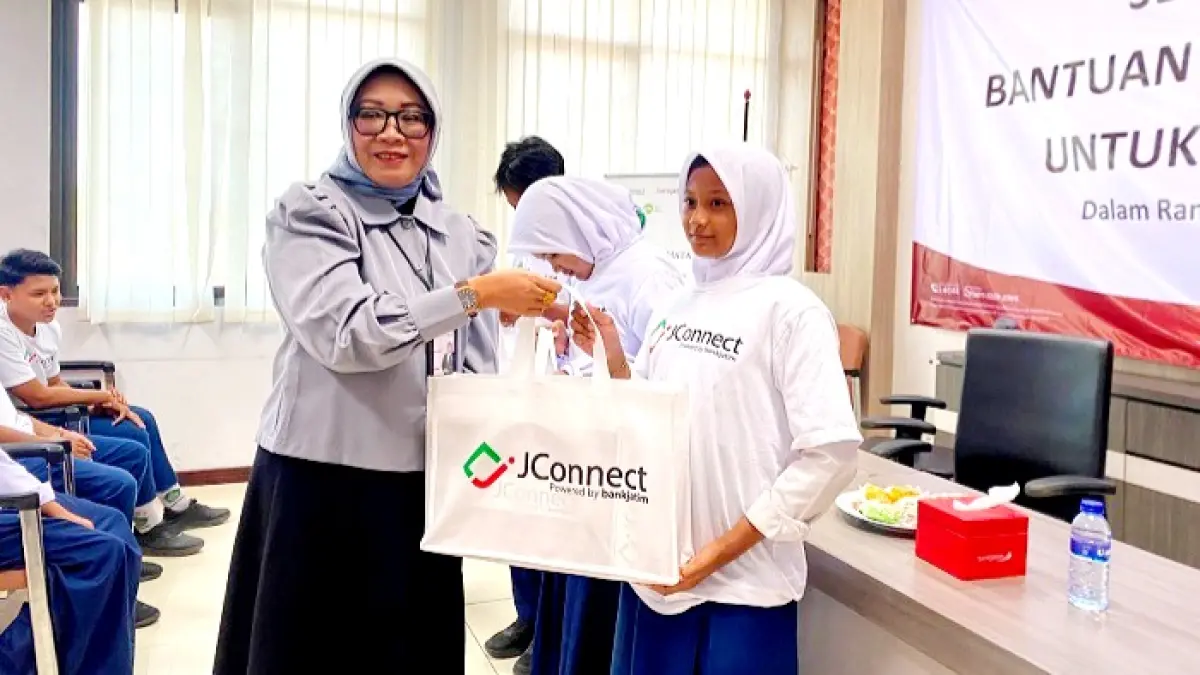 BERMANFAAT: Pemimpin Cabang Bank Jatim Sampang Erny Dewi S menyerahkan bantuan kacamata kepada pelajar di kantor Bank Jatim Sampang Selasa (18/8). (AYU LATIFAH/JPRM)