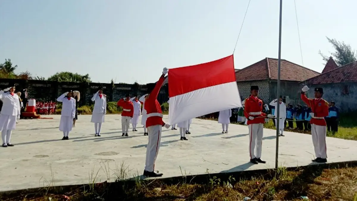 SUARA DARI DESA: Petugas Paskibraka membentangkan bendera dalam upacara HUT Ke-81 RI di Balai Desa Banyusangka, Kecamatan Tanjungbumi, Bangkalan, Senin (17/8). (INA HERDIYANA/JPRM)