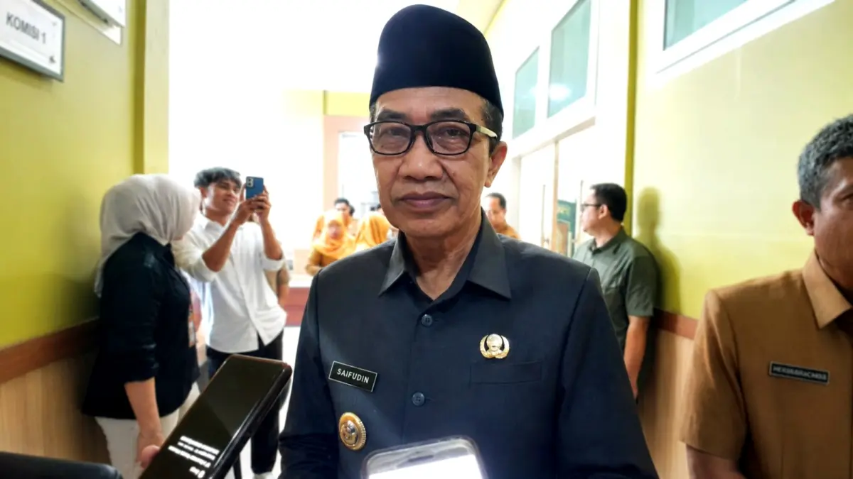 BERI PENJELASAN: Bupati KH Kholilurrahman saat wawancara cegat usai mengikuti sidang paripurna di DPRD Pamekasan, Selasa (18/8). (M. KHOLIL RAMLI/JPRM)