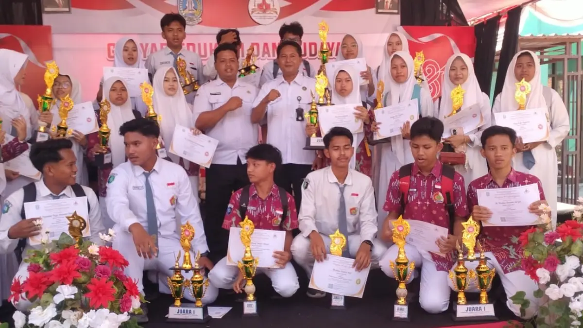 LUAR BIASA: Kepala SMAN 1 Sampang Akhmad Suhaili memakai tanda pengenal saat berfoto bersama dengan pelajar berprestasi di Kantor Cabdindik Jawa Timur Sampang Rabu (19/8). (SMAN 1 SAMPANG UNTUK JPRM)