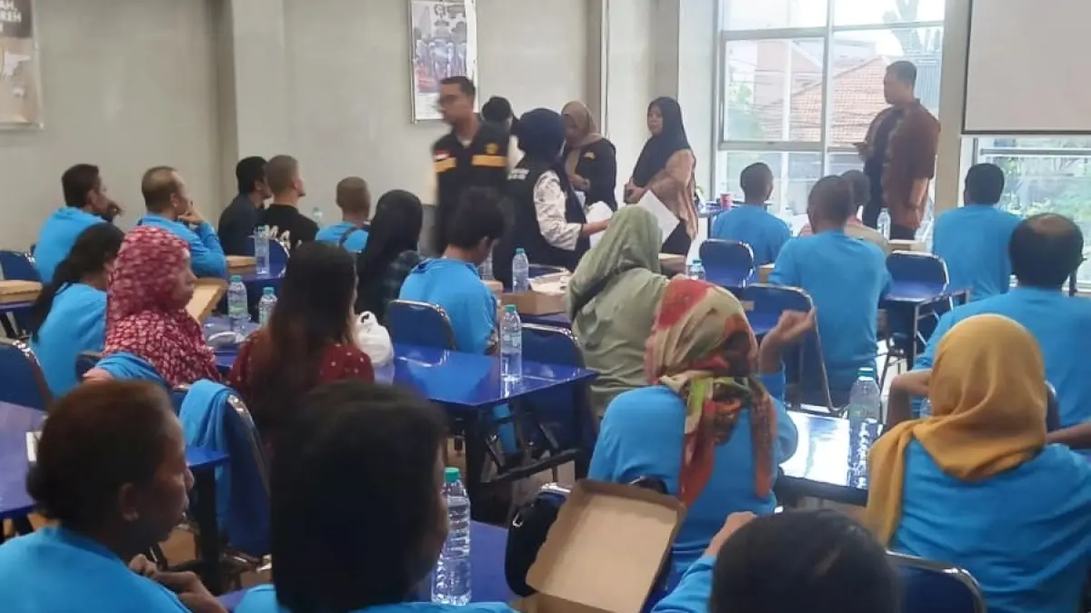 MELANGGAR: Petugas saat menjemput PMI yang dideportasi di Kantor Disnaker Sampang, Jumat (24/7).
