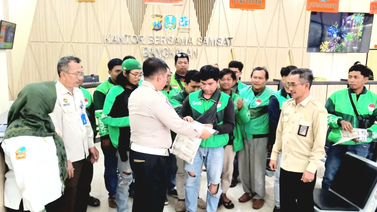 MERINGANKAN: Para ojek online (ojol) mengurus perpanjangan pajak kendaraan bermotor di Kantor Samsat Bangkalan Kamis (20/8). (ARI IRIADI UNTUK JPRM)