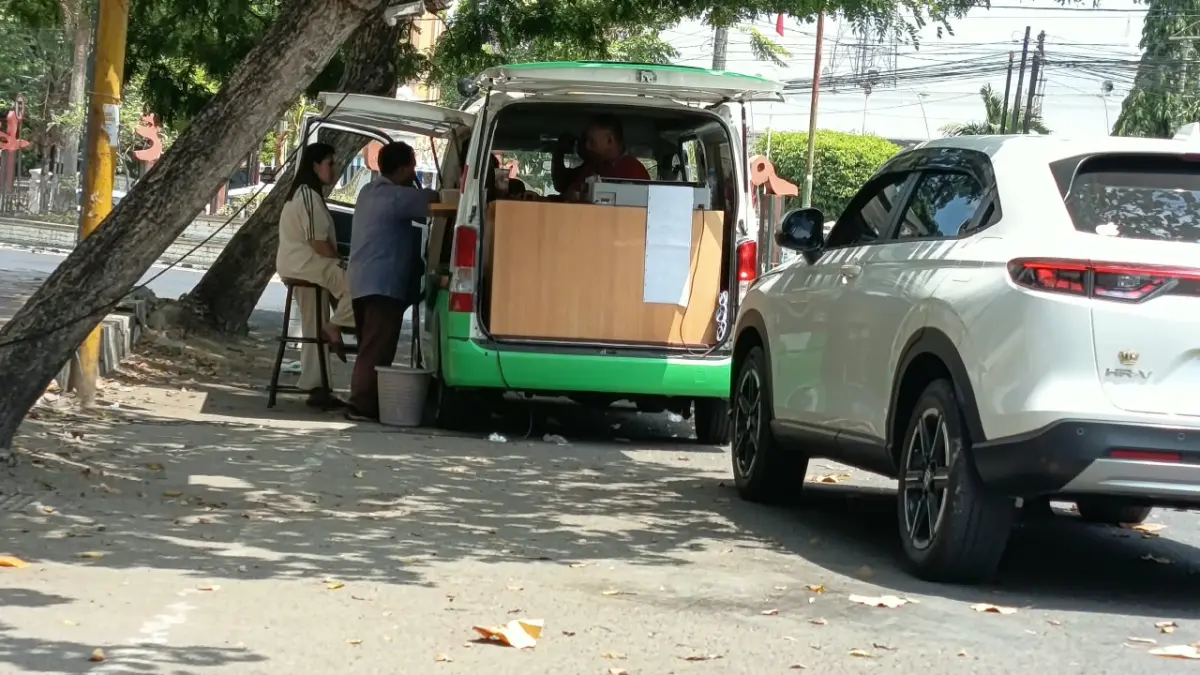 DIKELUHKAN: Warga sedang mengakses layanan Samling di Alun-Alun Bangkalan, Sabtu (22/8).