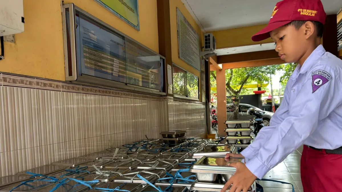 MAKANAN BERGIZI: Murid SDN Kemayoran 1 Bangkalan tengah mengecek ompreng MBG di sekolahnya, Senin (13/7).