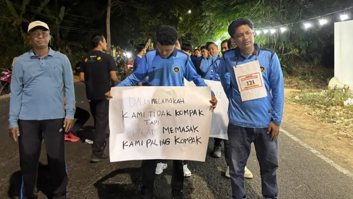SEMANGAT: Tim SPPG Sumenep Lenteng Lenteng Timur 3 bersiap menyusuri Jalan Raya Lenteng dalam lomba gerak jalan tingkat kecamatan pada Sabtu (22/8) malam.
