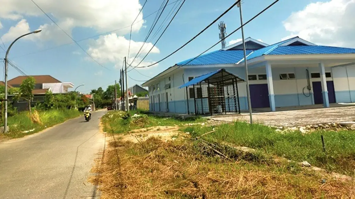 LENGANG: Pengendara sepeda motor melintas di depan dapur MBG di Kelurahan Mlajah, Bangkalan, Senin (11/5). (VIVIN AGUSTIN HARTONO/JPRM)