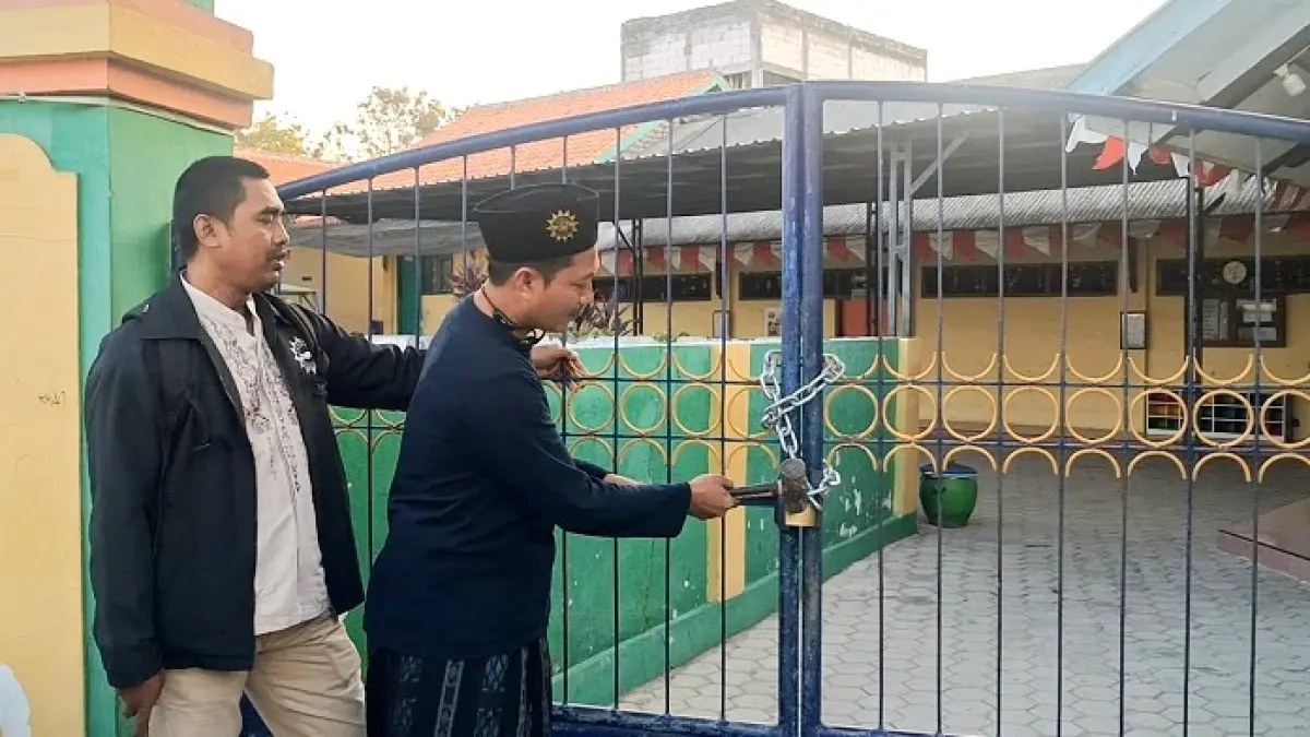 SENGKETA: PDM melepas gembok yang dipasang Nurul di pintu masuk sekolah Aisyiyah Bustanul Athfal IV Pamekasan, Selasa (25/8). (AHMAD FAUZI UNTUK JPRM)