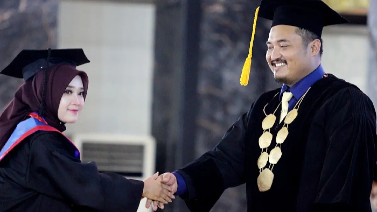 TUNTAS: Ketua STKIP PGRI Bangkalan Dr. Fajar Hidayatullah memberikan selamat kepada wisudawati di Gedung Serbaguna Rato Ebuh Bangkalan Kamis (27/8). (VIVIN AGUSTIN HARTONO/JPRM)