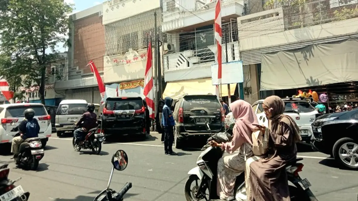 MACET: Juru parkir mengarahkan kendaraan roda empat di area Pecinan, Bangkalan, Kamis (27/8). (INA HERDIYANA/JPRM)