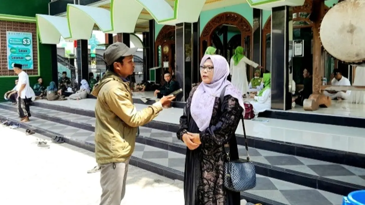 BERKACA-KACA: Wartawan JPRM saat mewawancarai Romlah Somad, warga nahdliyin Pamekasan, usai berziarah ke makam salah satu inspirator pendiri dan penggerak NU serta Pahlawan Nasional RI, KH Abdul Wahab Chasbullah, dalam momentum Muktamar Ke-35 NU, Kamis (27/8). (M. KHOLIL RAMLI/JPRM)