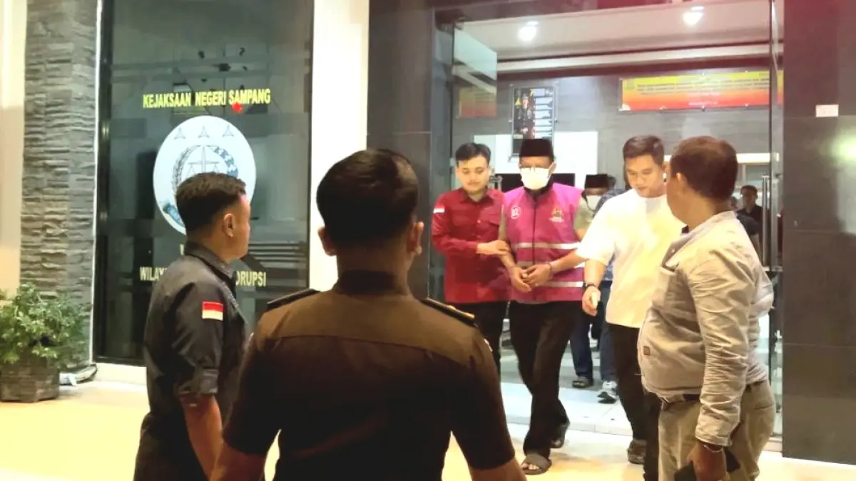 DIBORGOL: Eks Kepala Dispendik Sampang MF, tersangka kasus dugaan tipikor Dispendik Sampang, dikawal ketat petugas saat digiring menuju mobil tahanan Kejari Sampang, Kamis (27/8). (UBAIDILLAHIR RA’IE/JPRM)