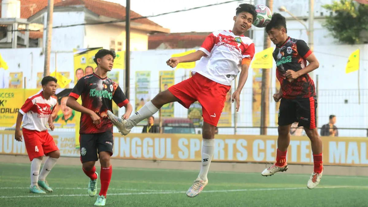 WAKILI MALANG: Penggawa Tim SMAN 1 Tumpang berebut bola atas dengan pemain MAN 1 Malang dalam laga semifinal pertama Bahlil Mini Soccer Asyik Menuju Puncak Zona Malang, Selasa (1/9) sore. (Darmono/Radar Malang)