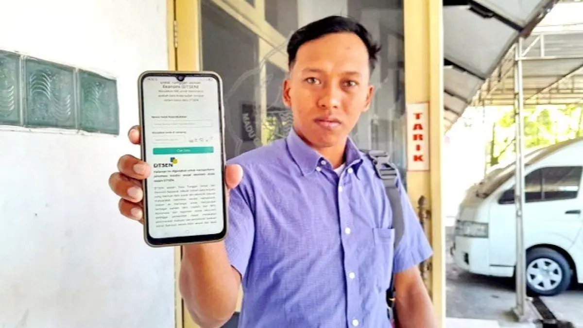 TIDAK AKURAT: Warga Pamekasan sedang menunjukkan cara mengecek desil pada DTSEN Rabu (2/9). (M. KHOLIL RAMLI/JPRM)