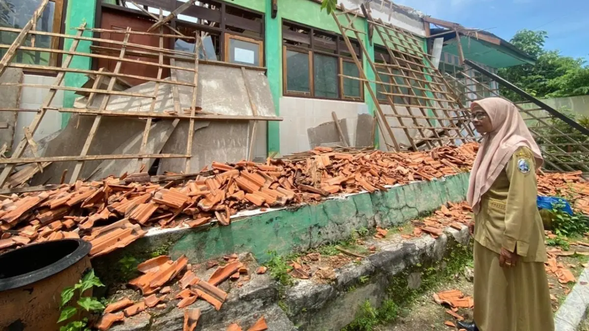 BUTUH PERBAIKAN: Surati saat melihat kondisi sekolahnya yang ambruk di SDN Rong Tengah 5, Sampang beberapa waktu lalu.