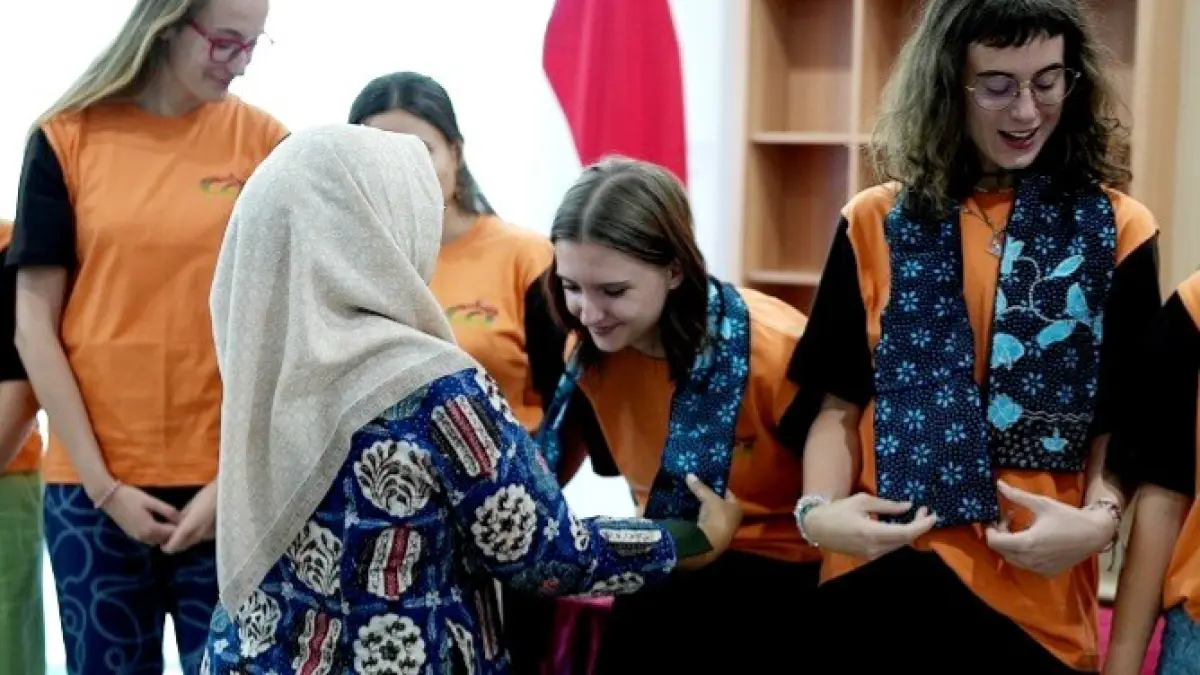 KEHANGATAN: Kepala Lembaga Penjaminan Mutu dan Pengembangan Pembelajaran (LPMPP) UTM Dr. Dinara Maya Julijanti, memakaikan kain batik kepada mahasiswa asal Palacky University. (UTM UNTUK JPRM)