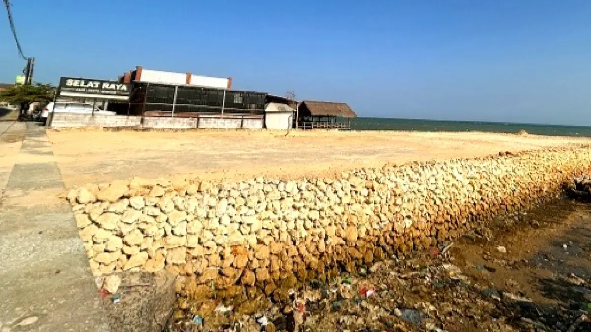 DIDUGA ILEGAL: Pekerja sedang berada di sekitar area penimbunan di sebelah Resto & Café Selat Raya di Desa Banjar Talela, Kecamatan Camplong, Sampang, Selasa (1/9). (UBAIDILLAHIR RA’IE/JPRM)