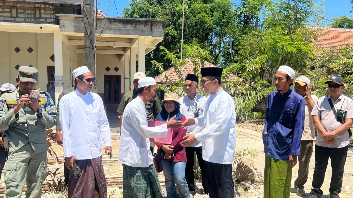 PEDULI: Bupati Pamekasan KH Kholilurrahman memberikan bantuan pribadi untuk perbaikan jalan swadaya di Desa Mangar, Kecamatan Tlanakan, Sabtu (5/9).