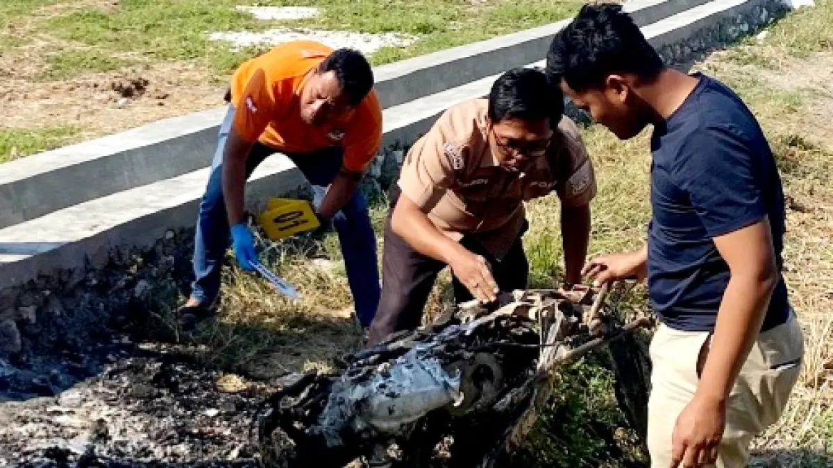 HANGUS: Petugas mengevakuasi motor Devita Ariani yang terbakar di area sawah, Kampung Bungsang, Kelurahan Mlajah, Bangkalan, Minggu (6/9). (HUMAS POLRES BANGKALAN UNTUK JPRM)