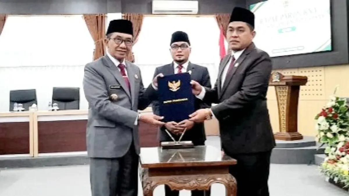 SINERGI: Bupati Pamekasan KH Kholilurrahman (kiri) menyerahkan naskah Perda Pertanggungjawaban Pelaksanaan APBD 2025 kepada Ketua DPRD Ali Masykur pada sidang paripurna, Senin (7/9). (M. KHOLIL RAMLI/JPRM)
