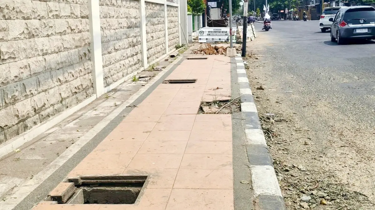 DIPERBAIKI: Trotoar di Jalan KH Moh. Kholil, Kelurahan Kemayoran, Bangkalan, yang jadi lokasi hilangnya penutup gorong-gorong dibongkar Rabu (9/9). (INA HERDIYANA/JPRM)