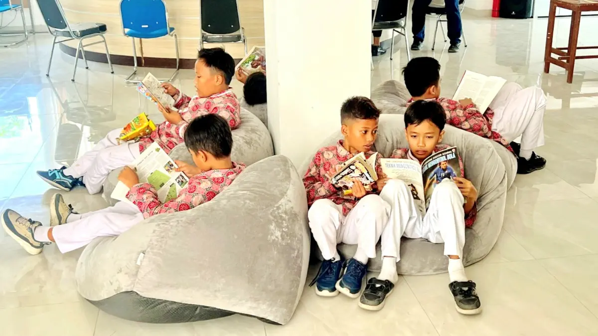 JENDELA DUNIA: Pengunjung perpustakaan daerah M. Tabrani Pemekasan sedang menikmati koleksi buku, Rabu (9/9). (M. KHOLIL RAMLI/JPRM)