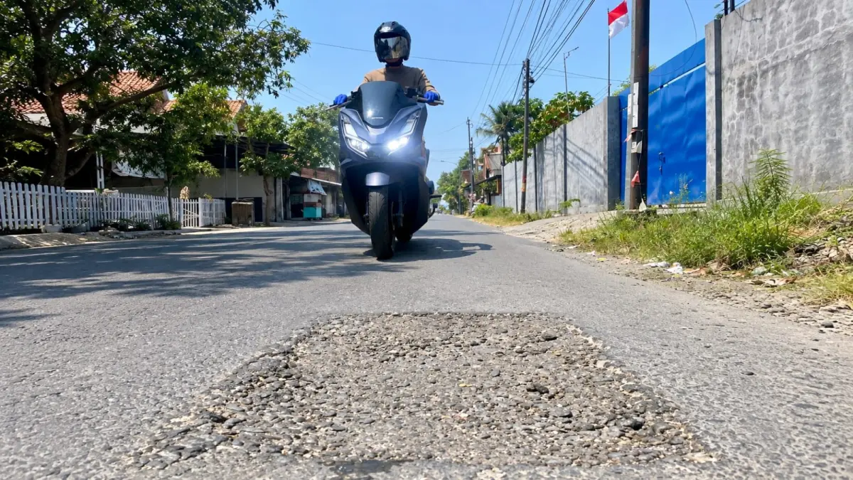 HATI-HATI: Pengendara melintas di bekas galian di Jalan Raya Pademawu, Pamekasan, Kamis (10/9). (MOH. IQBAL AFGANI/JPRM)