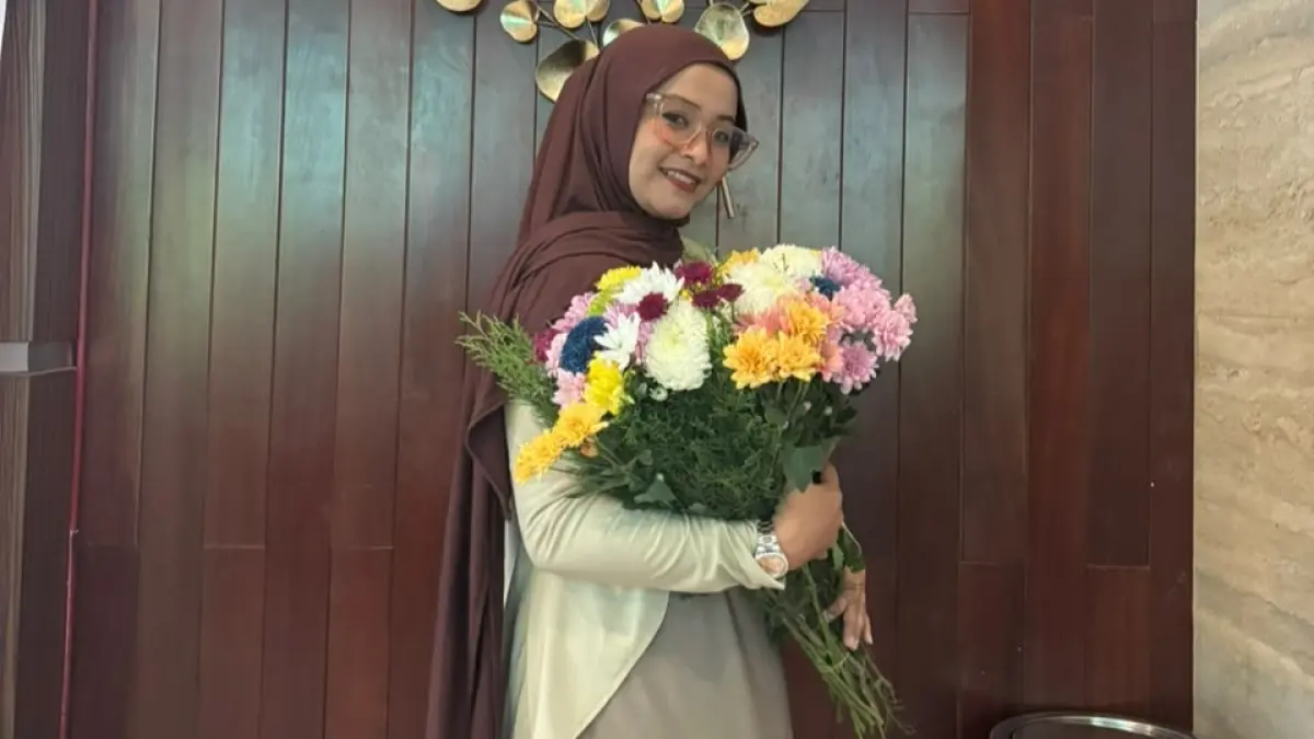 TELATEN: Himatun Nisa saat memegang biket hunga segar yang dibuatnya di rumah Desa Bangkal Kecamatan Kota Sumenep.