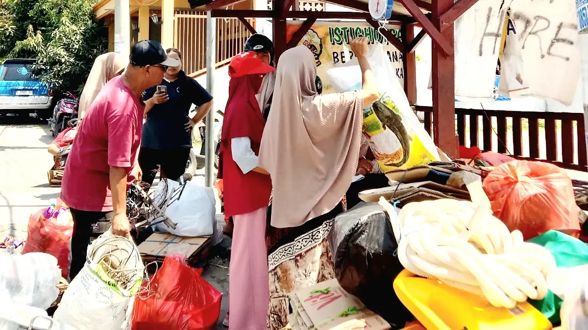BANK SAMPAH: Warga menimbang sampah di lapangan Perum Pondok Halim 2 Minggu (13/9). (INA HERDIYANA/JPRM)