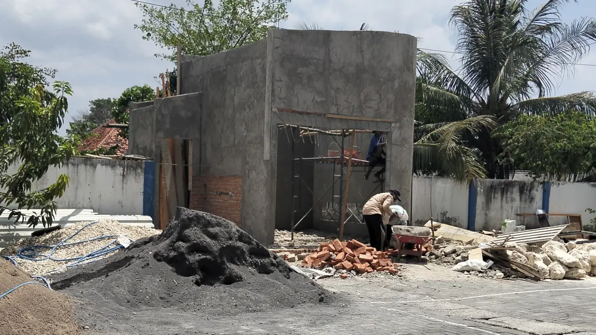 JANGGAL: Pekerja tanpa APD sedang mengerjakan pembangunan musala Puskesmas Jrengik, Sabtu (12/9). (ANIS BILLAH/JPRM)