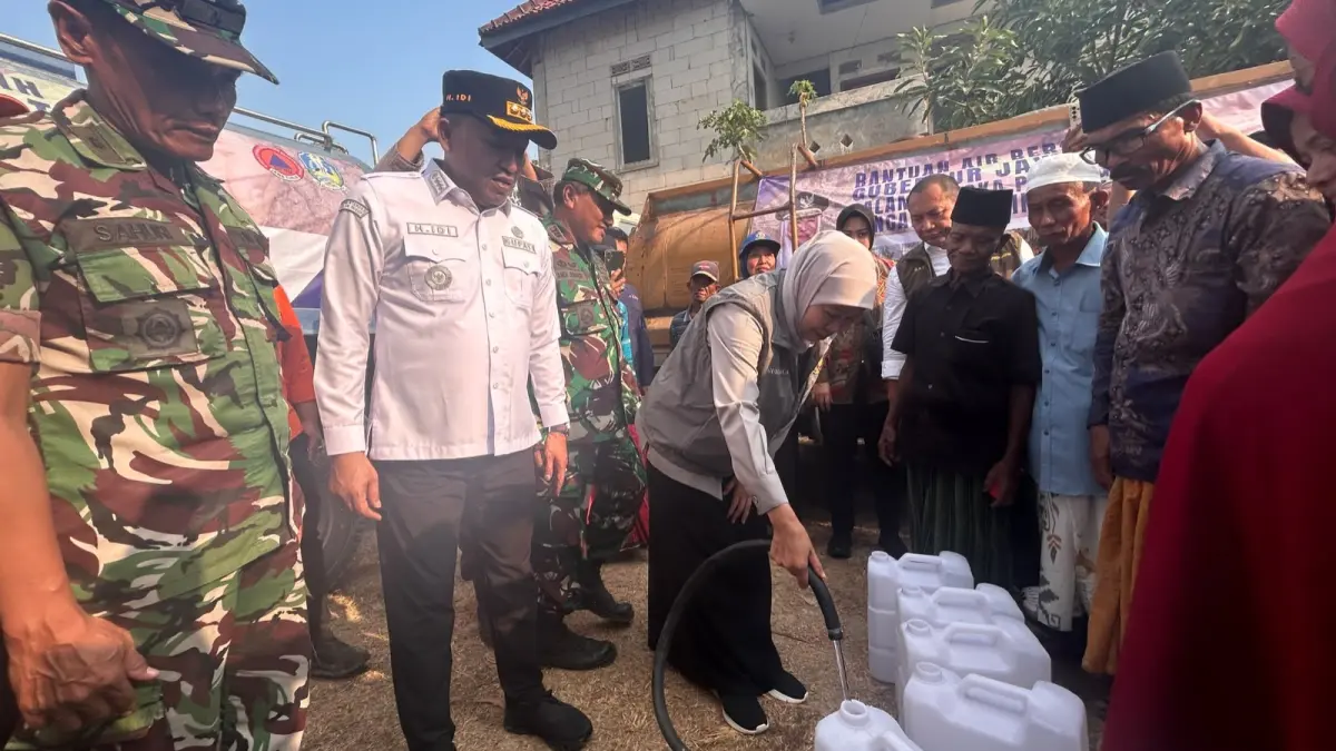 KEKERINGAN: Gubernur Jatim Khofifah Indar Parawansa didampingi Bupati Sampang Slamet Junaidi mengisi jeriken air milik warga di Desa Kedungdung, Kecamatan Kedungdung, Kamis (17/9). (UBAIDILLAHIR RA’IE/JPRM)