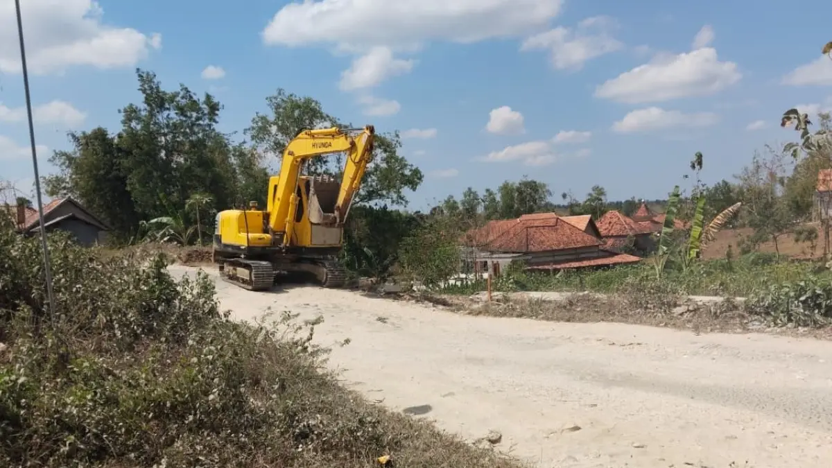 MULAI DIKERJAKAN: Alat berat mulai melakukan pekerjaan persiapan badan jalan dan galian dinding penahan tanah pada ruas Jalan Robatal-Karang Penang, Sampang. (DPUPR UNTUK JPRM)