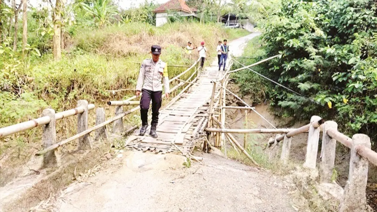 PENGHUBUNG: Petugas saat melakukan survei di jembatan Desa Karang Penang Oloh, Kecamatan Karang Penang, Sampang, Rabu (3/6). (BPBD UNTUK JPRM)