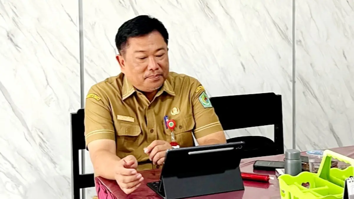 TRANSPARAN: Kepala Dinsos Pamekasan Herman Hidayat Santoso mengecek data KPM BLT DBHCHT 2026 saat ditemui di kantornya, Jumat (18/9). (M. KHOLIL RAMLI/JPRM)