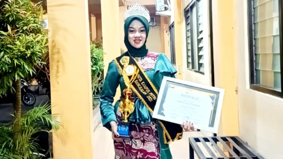 MULTITALENTA: Imelda Gihan memegang piala dan trofi Winner Duta Putri Kampus STKIP PGRI Bangkalan pada Jumat (29/5). (SULISTIAWATI UNTUK JPRM)