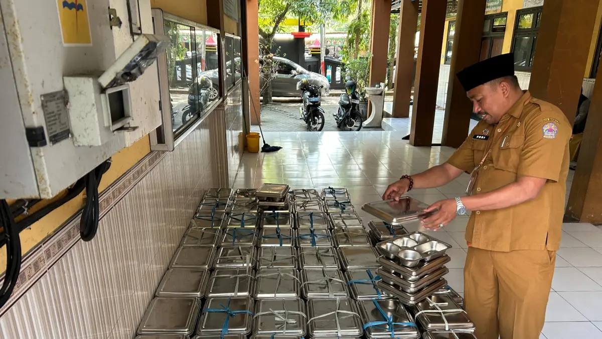 TELITI: Guru SDN Kemayoran 1 Bangkalan mengecek ompreng makanan sebelum dikembalikan ke SPPG, Senin (13/7).