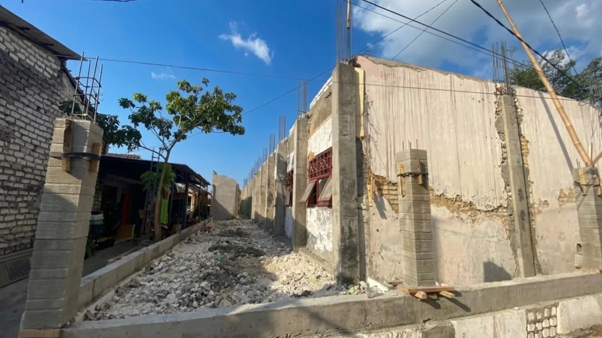 REHABILITASI: Warga berada di dekat proyek revitalisasi SDN Pangeranan 1 Bangkalan, Minggu (27/9).