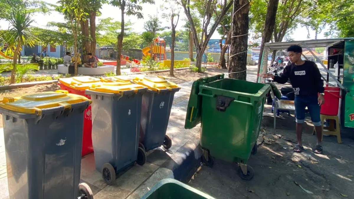 RETRIBUSI: Pemuda saat membuang sampah di sekitar Alun-Alun Trunojoyo beberapa waktu lalu.