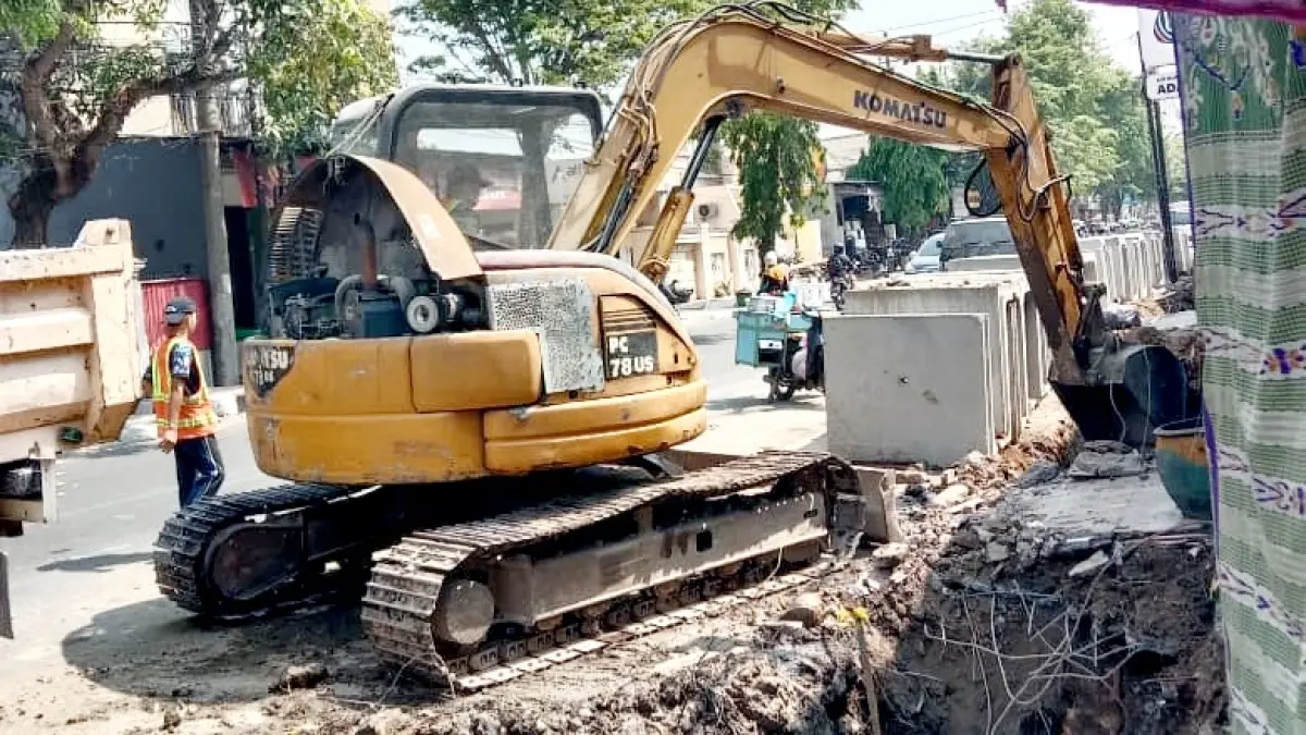 WASPADA: Pekerja melakukan pengerukan menggunakan ekskavator di Jalan KH Moh. Kholil, Bangkalan, Rabu (30/9). (INA HERDIYANA/JPRM)